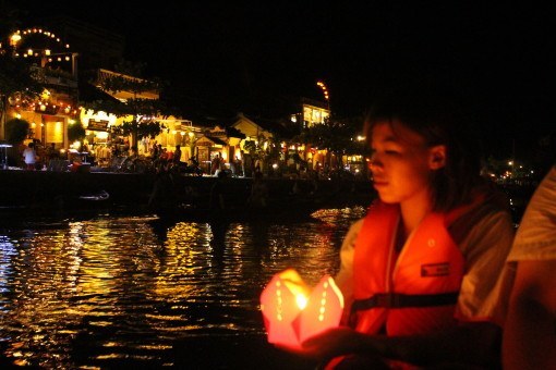 Setting lanterns adrift as we float along the Thu Bon River